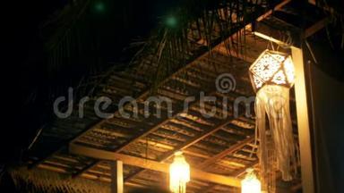 <strong>大气背景</strong>拍摄的夜晚露台上美丽的弦灯，传统的纸灯笼在风中挥动。